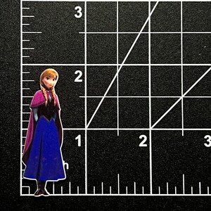 Puede incluir: Una imagen impresa de un personaje de dibujos animados, una joven con el pelo largo, trenzado y casta&ntilde;o, que lleva un vestido azul con una capa morada y botas negras. El personaje est&aacute; de pie sobre un fondo de cuadr&iacute;cula blanca.