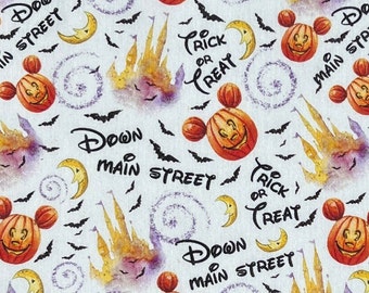 May include: A white fabric with a repeating pattern of Mickey Mouse heads with jack-o-lantern faces, a castle, bats, moons, and the text "Down Main Street" and "Trick or Treat".