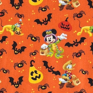 May include: Orange Halloween-themed fabric featuring cartoon characters Mickey Mouse, Donald Duck, and Pluto in costumes. The design includes bats, spiders, and jack-o'-lanterns. The fabric is covered in small yellow dots.