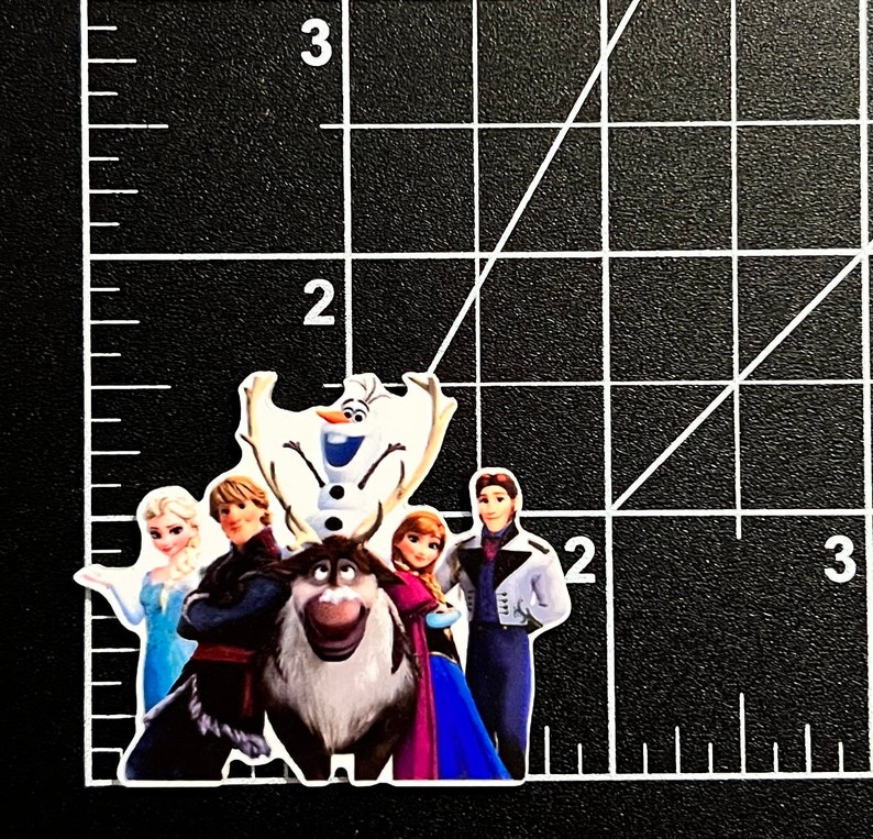 Puede incluir: Una pegatina con los personajes de la pel&iacute;cula Frozen. La pegatina muestra a Elsa, Anna, Kristoff, Olaf y Sven. Los personajes est&aacute;n de pie frente a un fondo azul y blanco.