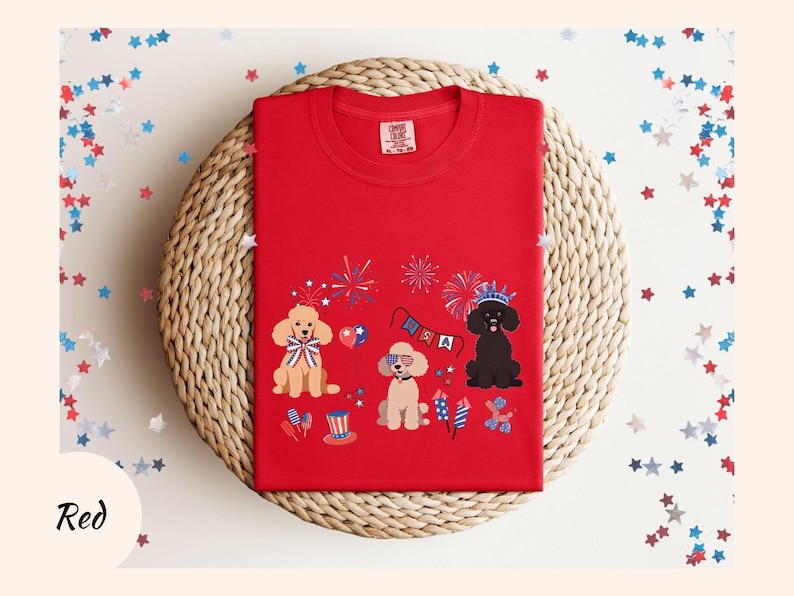 May include: Red t-shirt with a graphic of three dogs wearing party hats and celebrating with fireworks and a banner that says "USA".