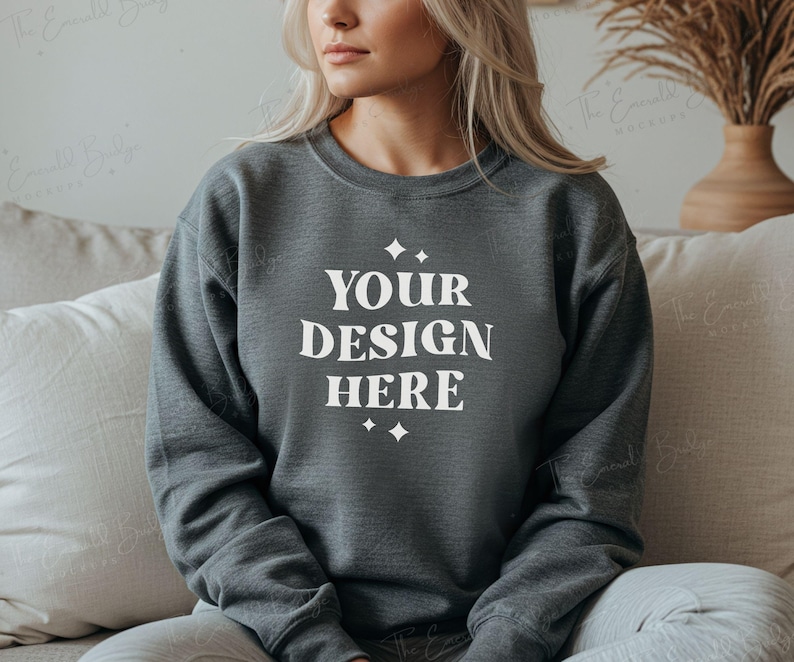 May include: A dark gray sweatshirt with the text "YOUR DESIGN HERE" in white lettering. The sweatshirt has a crew neck and long sleeves.