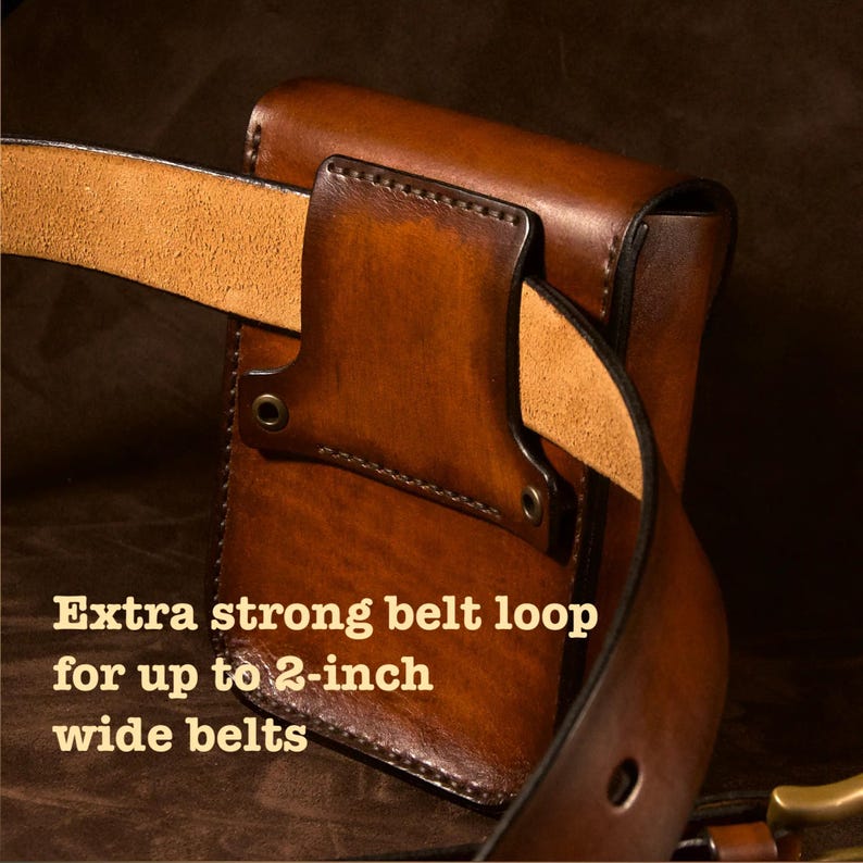 May include: A brown leather belt pouch with a belt loop designed for up to 2-inch wide belts. The pouch is a rich, dark brown color with visible stitching and metal rivets. The text "Extra strong belt loop for up to 2-inch wide belts" is visible.
