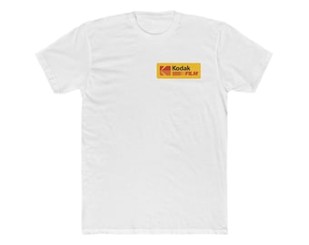 May include: A white short-sleeved t-shirt featuring a rectangular yellow logo on the left chest. The logo contains the red Kodak symbol on the left side, followed by the black text Kodak and the red text FILM on the right side of the yellow rectangle.
