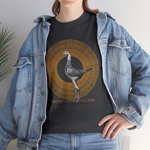 May include: A dark grey t-shirt with a graphic of a rooster in a gold Greek key pattern circle. The text "MODERN GAME BANtams" is below the graphic.