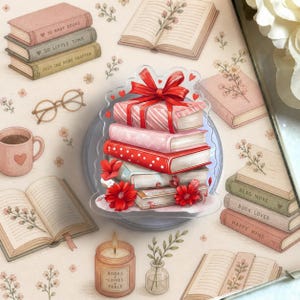 May include: An illustration featuring a stack of books with a red bow, surrounded by other books, a coffee mug, and a candle. The books are in shades of pink, red, and green. The candle has the text "BOOKS COFFEE PEACE".