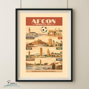 May include: A framed poster with a vintage travel theme, featuring illustrations of Moroccan cities like Casablanca and Marrakech. The poster has the text "AFCON - MOROCCO 2025" and celebrates African football. The color palette includes warm tones of beige, brown, and orange.