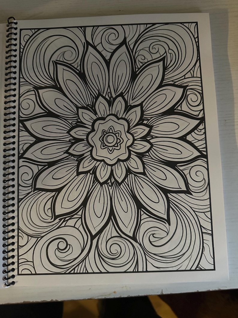 Puede incluir: Una p&aacute;gina para colorear en blanco y negro con un dise&ntilde;o de mandala detallado con una gran flor en el centro rodeada de patrones en espiral.