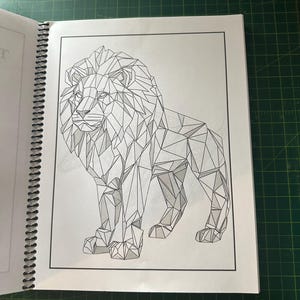 K&ouml;nnte beinhalten: Eine geometrische Schwarzwei&szlig;zeichnung eines L&ouml;wen mit einer gro&szlig;en M&auml;hne. Der L&ouml;we steht auf allen vieren und hat ein detailliertes, kompliziertes Design.