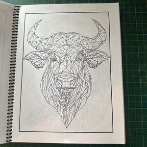 K&ouml;nnte beinhalten: Eine Schwarzwei&szlig;-Zeichnung eines Bullenkopfes im geometrischen Stil. Der Bullenkopf besteht aus vielen Dreiecken und Linien, die ein detailliertes und komplexes Design ergeben.