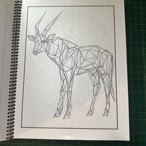 K&ouml;nnte beinhalten: Eine Schwarzwei&szlig;-Zeichnung eines Antilopen mit langen H&ouml;rnern, im geometrischen Stil dargestellt. Die Antilope steht auf einem wei&szlig;en Hintergrund.