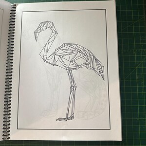 K&ouml;nnte beinhalten: Eine Schwarzwei&szlig;-Linienzeichnung eines Flamingos im geometrischen Stil. Der Flamingo steht auf einem Bein mit gebogenem Hals.