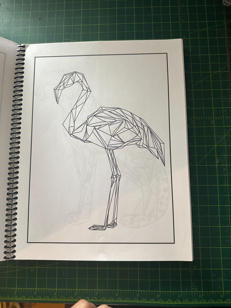 K&ouml;nnte beinhalten: Eine Schwarzwei&szlig;-Linienzeichnung eines Flamingos im geometrischen Stil. Der Flamingo steht auf einem Bein mit gebogenem Hals.