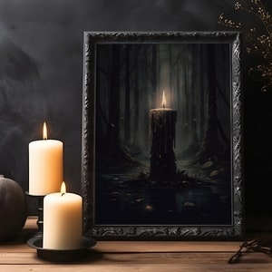 Pode incluir: Uma impress&atilde;o emoldurada em preto de uma cena de floresta escura com uma &uacute;nica vela acesa no centro. A vela est&aacute; pingando cera e a floresta est&aacute; envolvida em n&eacute;voa. A impress&atilde;o &eacute; cercada por duas velas brancas em casti&ccedil;ais pretos.