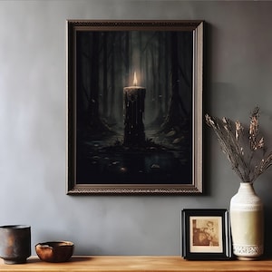 Pode incluir: Uma impress&atilde;o emoldurada de uma cena de floresta escura com uma &uacute;nica vela acesa no centro. A vela est&aacute; pingando cera e est&aacute; cercada por folhas e galhos ca&iacute;dos. O fundo &eacute; uma floresta escura e nebulosa.