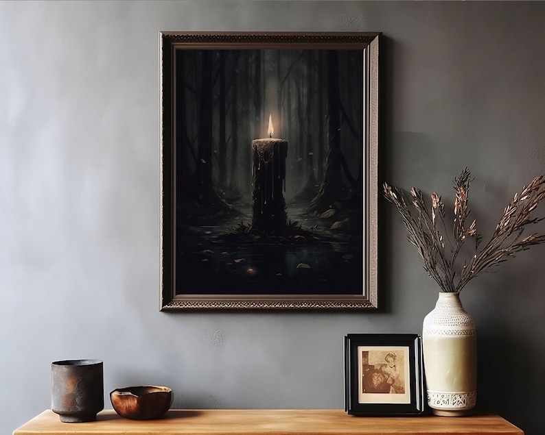 Pode incluir: Uma impress&atilde;o emoldurada de uma cena de floresta escura com uma &uacute;nica vela acesa no centro. A vela est&aacute; pingando cera e est&aacute; cercada por folhas e galhos ca&iacute;dos. O fundo &eacute; uma floresta escura e nebulosa.