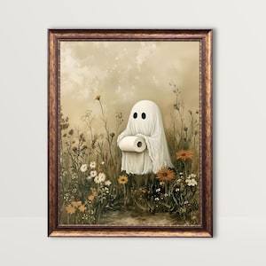 Pode incluir: Uma impressão artística emoldurada com um fantasma segurando um rolo de papel higiênico, em um campo de flores silvestres. O fantasma, com dois olhos pretos, está envolto em um lençol branco. A moldura é marrom escuro.