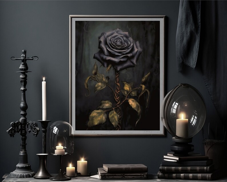 May include: A framed print of a dark, almost black rose with a twisted stem and green leaves against a dark background. The print is displayed on a dark wall with candles and other decor.