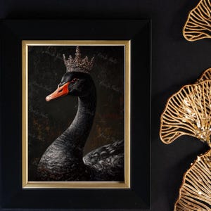 Pu&ograve; includere: Opera d'arte incorniciata con un cigno nero incoronato, becco rosso, su sfondo scuro. La cornice nera con bordo interno dorato esalta l'estetica regale dell'immagine.