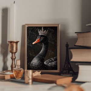 Pu&ograve; includere: Stampa artistica incorniciata raffigurante un cigno nero con una corona. Il cigno ha un becco arancione ed &egrave; in una cornice dorata. L'opera d'arte &egrave; esposta su un tavolo con altri oggetti decorativi.