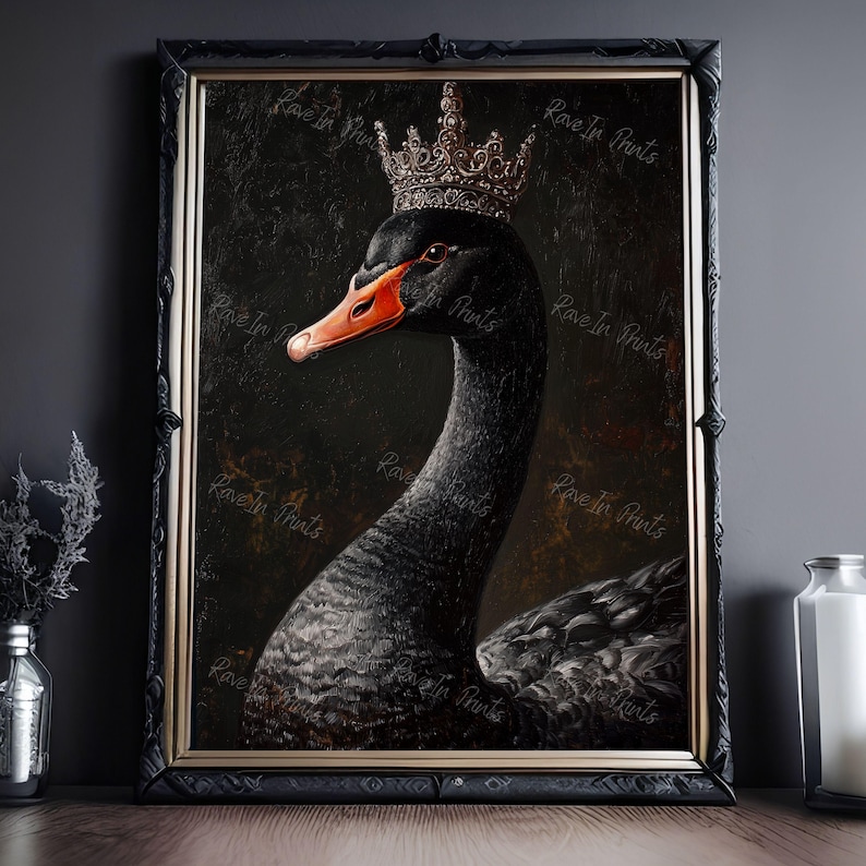 Pu&ograve; includere: Una stampa artistica incorniciata raffigurante un cigno nero con una corona. Il cigno ha un becco rosso ed &egrave; ambientato su uno sfondo scuro e strutturato. La cornice &egrave; nera e la stampa &egrave; etichettata con "Rave In Prints".