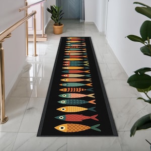 May include: A long, rectangular runner rug with a black background featuring a repeating pattern of stylized fish in various colors including orange, yellow, teal, and red. The fish are arranged in a single vertical column, each with distinct patterns.