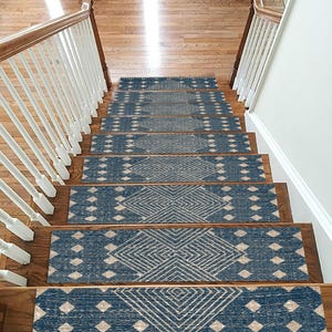 May include: A set of rectangular stair treads featuring a deep blue background with a repeating geometric pattern in a light beige color. Each tread displays a central diamond motif composed of thin lines, flanked by smaller diamond shapes.