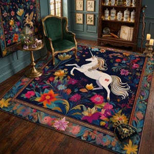Può includere: Un tappeto rettangolare con sfondo blu scuro, un'illustrazione centrale di un unicorno bianco e motivi floreali colorati. Il tappeto presenta un bordo decorativo con intricati disegni botanici e dettagli in oro.