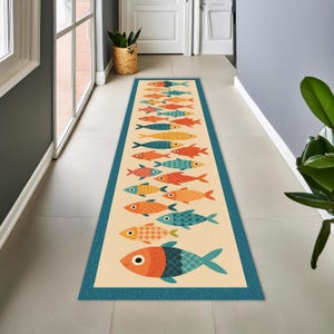 Peut inclure: Un long tapis de couloir rectangulaire au centre crème, orné d'un motif répétitif de poissons stylisés dans des tons orange, rouge, jaune et bleu sarcelle. Le tapis est encadré par une bordure bleu sarcelle unie à l'aspect texturé.