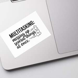May include: White sticker with black text that reads "MULTITASKING: messing up several things at once."  A simple black line drawing of several squares stacked on top of each other is to the right of the text.