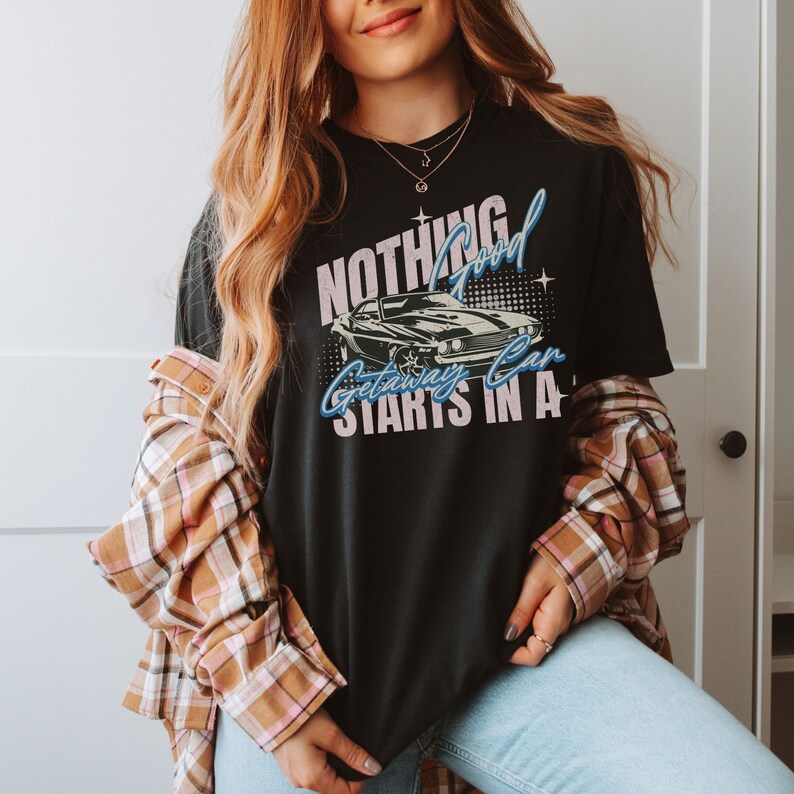 May include: A black t-shirt with a graphic print of a vintage car and the text "Nothing good getaway starts in a..."