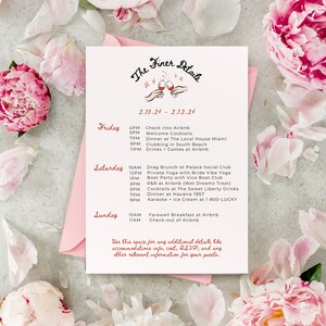 May include: A pink and white floral background with a white card featuring a handwritten schedule of events for a weekend getaway. The card has the title "The Finer Details" with a graphic of two hands holding wine glasses. The schedule includes events for Friday, Saturday, and Sunday, with times and locations for each event.