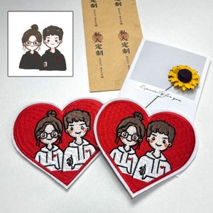 Könnte beinhalten: Zwei rote herzförmige gestickte Aufnäher mit weißen Umrandungen. Jeder Aufnäher zeigt ein Cartoon-Paar, das weiße Hoodies mit roten Herzen auf der Vorderseite trägt. Das Paar lächelt und hält sich an den Händen. Der Text "Especially for you" ist im Hintergrund sichtbar.