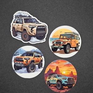 May include: Four die-cut stickers featuring off-road vehicles. The stickers depict a tan SUV on snow, an orange SUV on snow, an orange vintage SUV on a beach, and a light blue truck in a desert landscape.