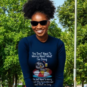 May include: A navy blue long-sleeve shirt with a penguin graphic and the text "You Don't Need To Worry About What I'm Doing. You Just Need To Worry About Why You're Worried About What I'm Doing."