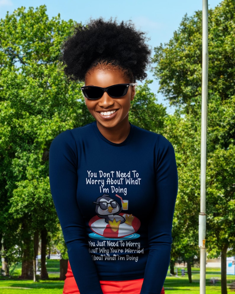 May include: A navy blue long-sleeve shirt with a penguin graphic and the text "You Don't Need To Worry About What I'm Doing. You Just Need To Worry About Why You're Worried About What I'm Doing."