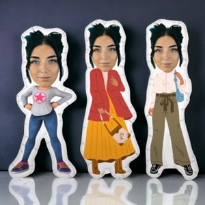 May include: Three white fabric dolls with different outfits and hairstyles. The dolls have cartoon-style faces with exaggerated features. The doll on the left is wearing a grey shirt with a pink star, blue jeans, and white trainers. The doll in the middle is wearing a red jacket, a yellow skirt, brown boots, and a brown handbag. The doll on the right is wearing a white shirt, brown trousers, brown shoes, and a blue handbag.