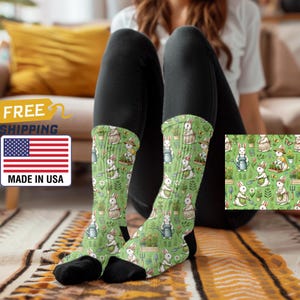 May include: A pair of green socks with a white rabbit gardening pattern. The rabbits are wearing hats and holding gardening tools. The socks are made in the USA and have free shipping.