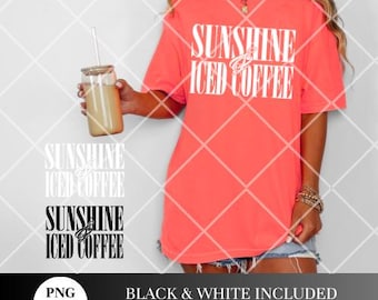 May include: A pink t-shirt with the text "Sunshine & Iced Coffee" in white letters. The shirt is being worn by a person holding a glass of iced coffee.