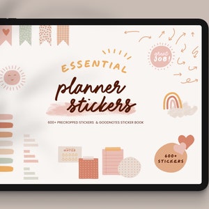 May include: A digital tablet displaying a collection of planner stickers in a variety of colours and designs. The stickers include a sun, a rainbow, hearts, and a water bottle. The text "ESSENTIAL planner stickers" is displayed on the screen. The text "600+ PRECROPPED STICKERS & GOODNOTES STICKER BOOK" is also displayed on the screen.