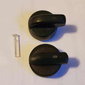 Peut inclure: Deux boutons de cuisinière noirs avec un point blanc sur chacun. Un axe de bouton en plastique transparent est également inclus.