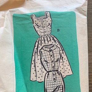 Puede incluir: Patrón de costura vintage para un vestido con dos estilos. El patrón está impreso sobre un fondo verde claro y muestra un vestido de lunares blanco y negro y un vestido de cuadros blanco y negro. El número de patrón es 4591 y la talla es 16.