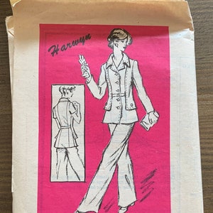 May include: A vintage sewing pattern for a pantsuit. The pattern is printed on pink paper and features a line drawing of a woman wearing the pantsuit. The pattern is for size 18 1/2 and is labelled "Prominent Designer A659 - Size 18 1/2".