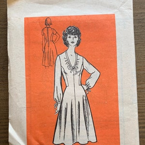 May include: A vintage sewing pattern for a dress with a bow at the neckline. The pattern is printed on orange paper and includes a drawing of a woman wearing the dress. The pattern number is 9484 and the size is 16.
