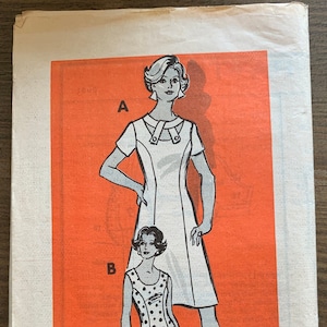 Puede incluir: Patrón de costura vintage para un vestido con cuello y mangas cortas. El patrón está impreso en papel naranja e incluye dos estilos diferentes. El número del patrón es 9031 y la talla es 18 1/2.