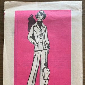 Può includere: Cartamodello vintage con l'illustrazione di una donna in tailleur pantalone. Il modello è stampato su sfondo rosa con la scritta "Printed Pattern" e la taglia 14.