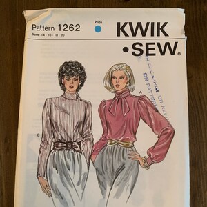 May include: A sewing pattern for a blouse with a bow tie and a skirt. The pattern is from Kwik Sew Pattern Co., Inc. and is for sizes 14-16-18-20.