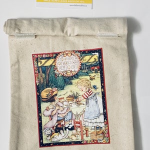 May include: A beige canvas tote bag with a colorful illustration of two girls having tea. The illustration includes the text "UNTO OTHERS AS YOU WOULD HAVE THEM DO UNTO" and "FOR ME".