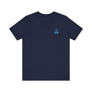 May include: A navy blue t-shirt with a small, blue and white geometric logo on the left chest.