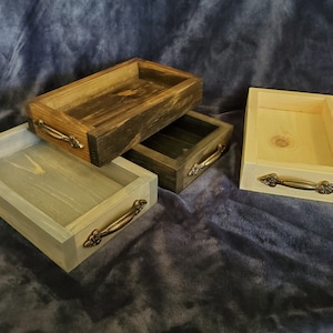May include: Four wooden trays with decorative metal handles. The trays are in various shades of brown, gray, and natural wood.